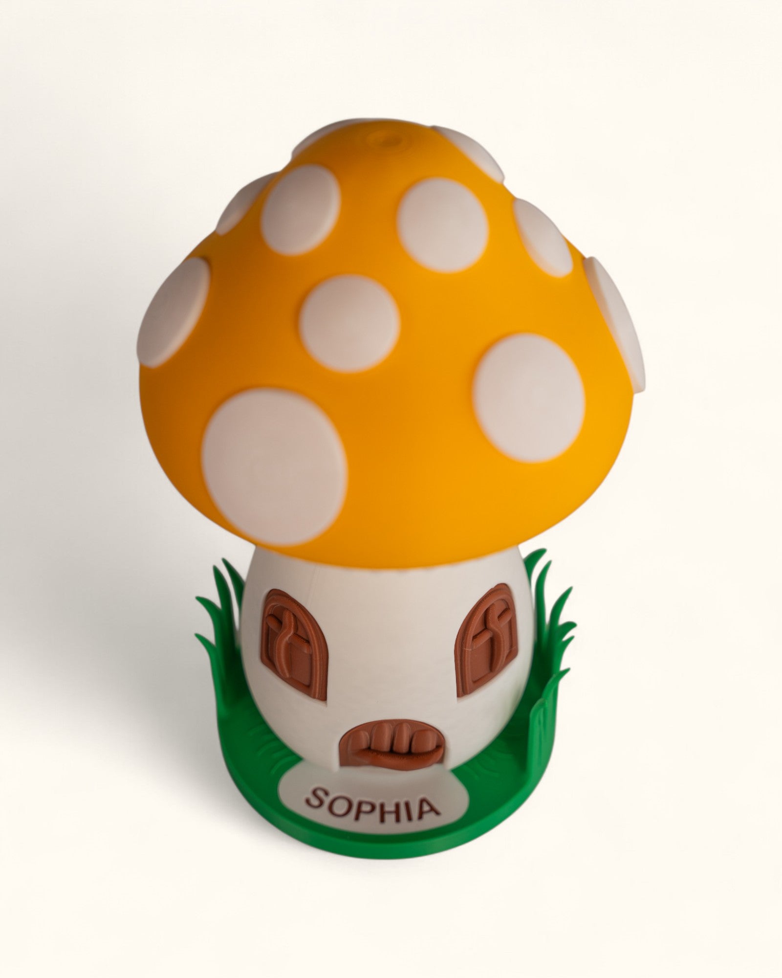 3D printed mushroom jewelry organizer with white spots, doors, windows as storage and green grass ring holder base and custom text printed on doorstep.