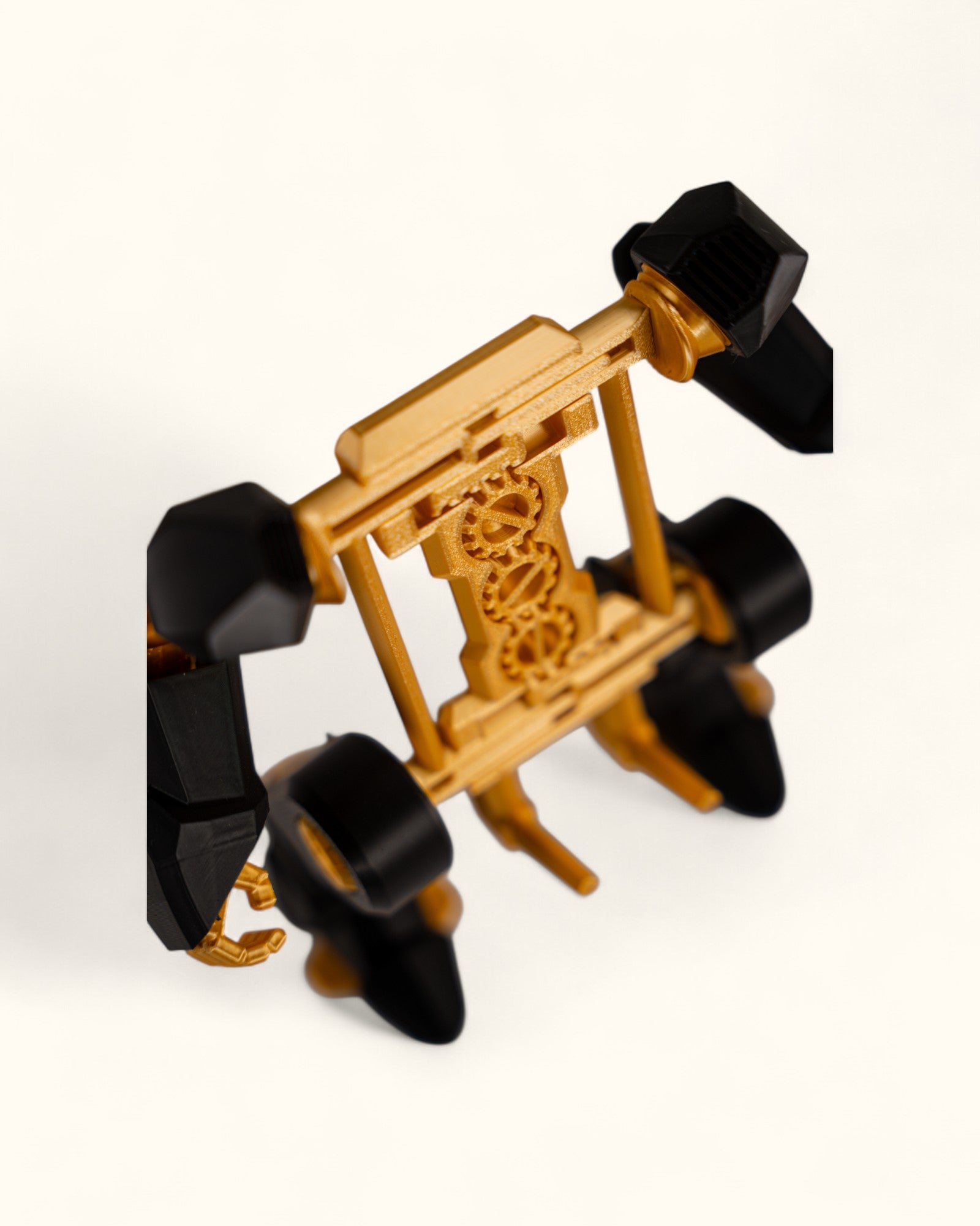 3D-printed mech-inspired phone stand with detailed armour plates, gear design, and hand feature for holding a charging cable, adjustable to fit most modern smartphones.