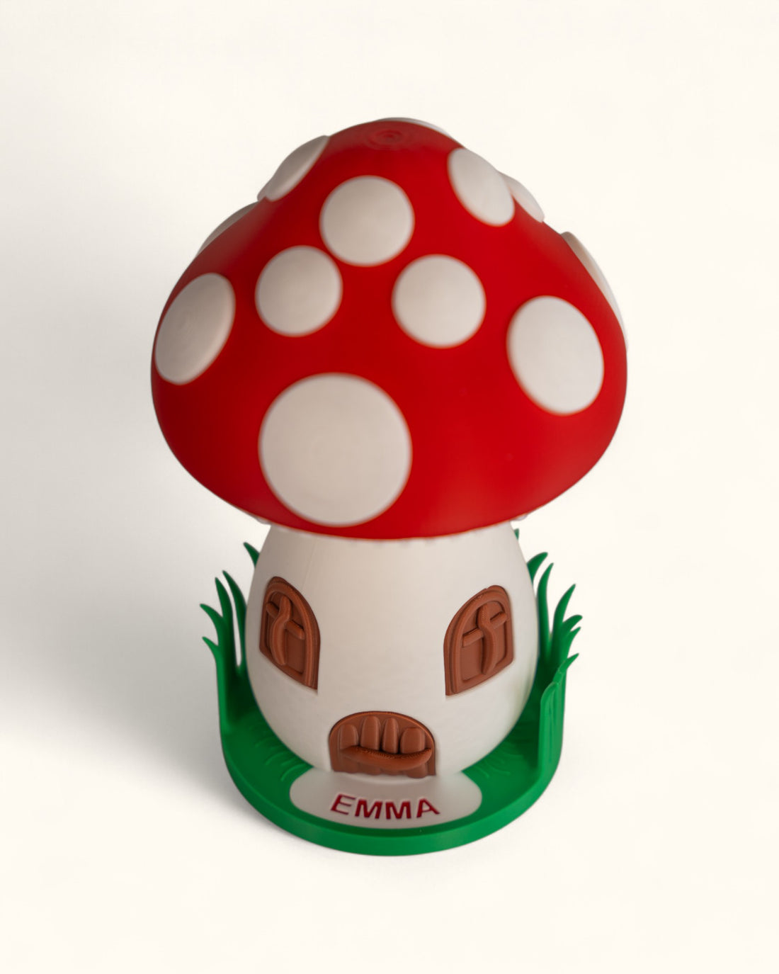 3D printed mushroom jewelry organizer with white spots, doors, windows as storage and green grass ring holder base and custom text printed on doorstep.