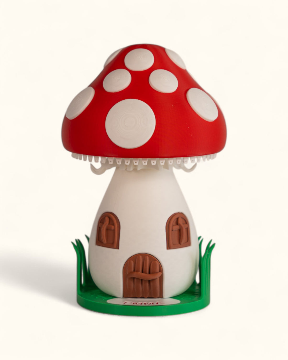 3D printed mushroom jewelry organizer with white spots, doors, windows as storage and green grass ring holder base and custom text printed on doorstep.